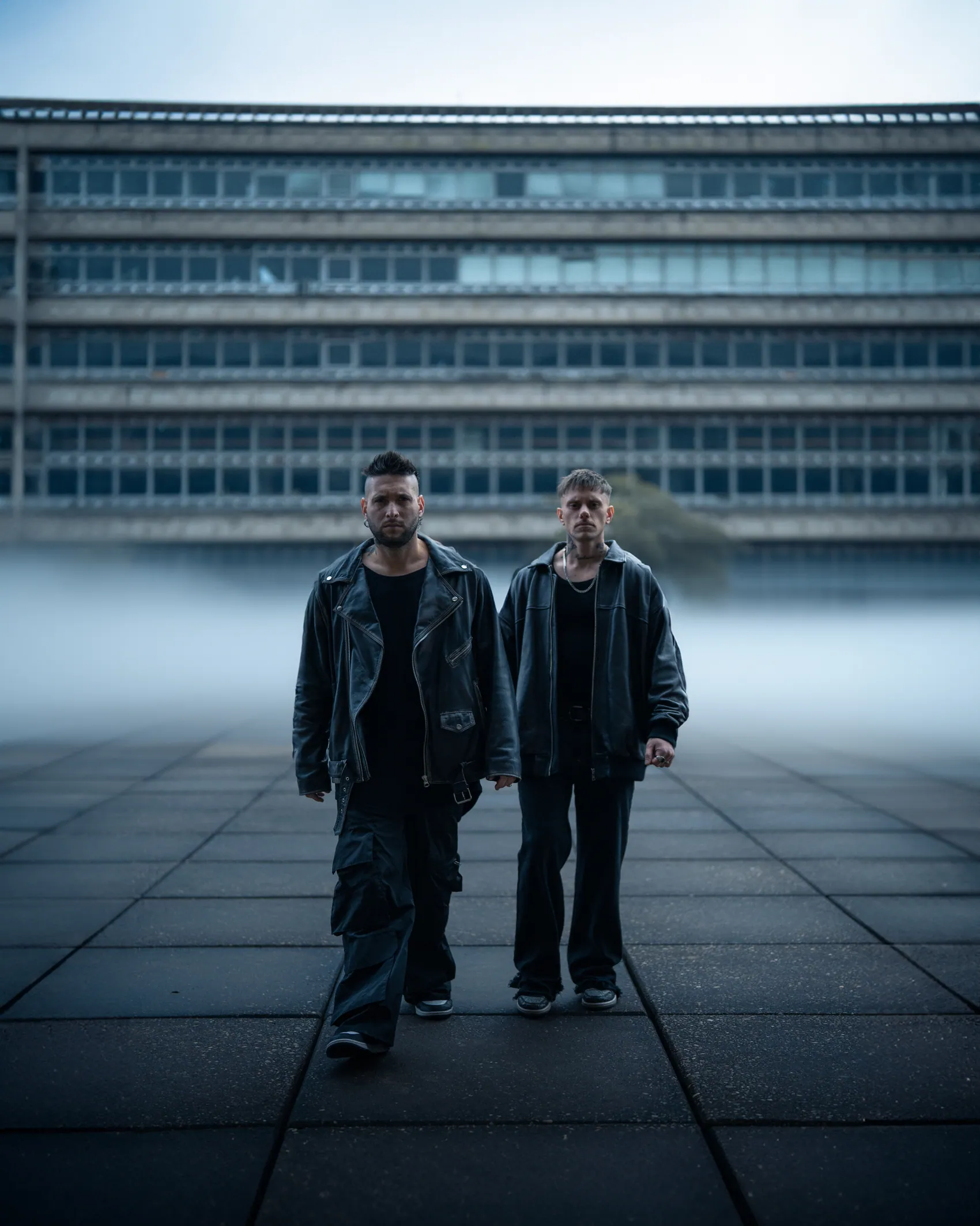 BOB TOSH caminando frente a un edificio modernista entre la niebla